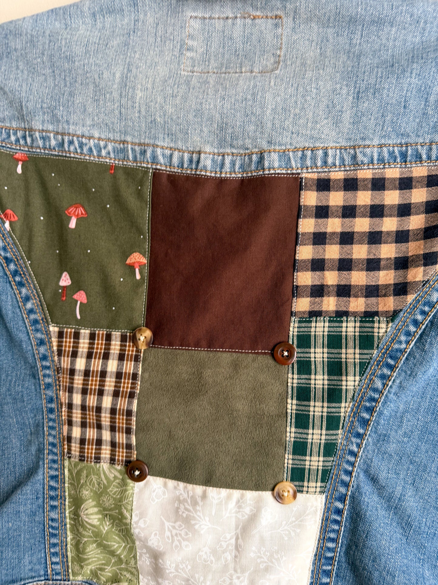 Patchwork design on a denim vest with various patterns and colors.