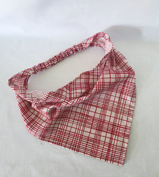 A red and white plaid hair bandana, shown laid flat on a white fabric background.