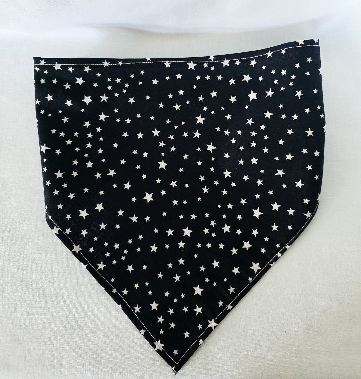 HAir bandana laid flat on a white background. The bandana is black with white stars. 