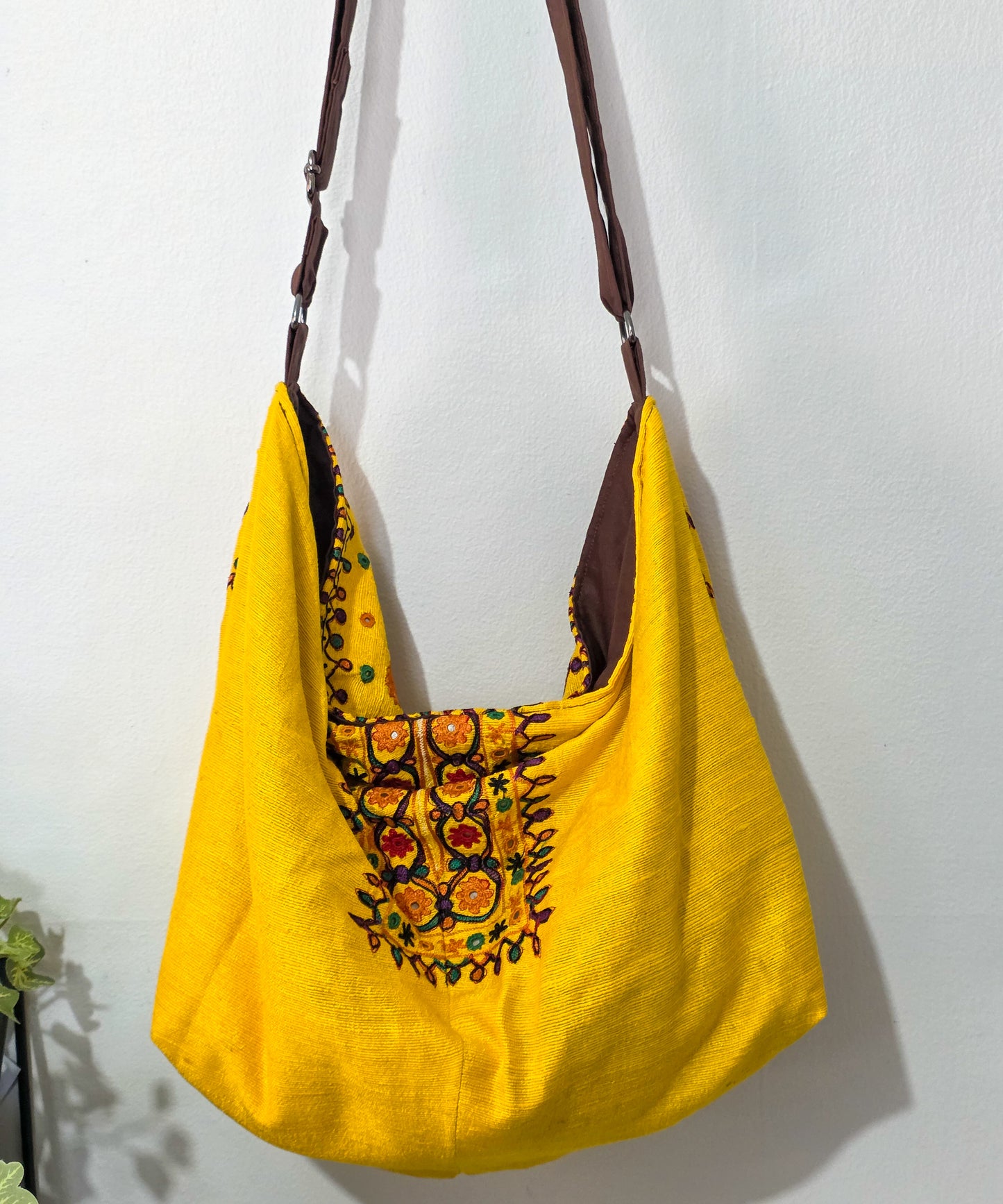 Yellow handbag with floral embroidery on a white background