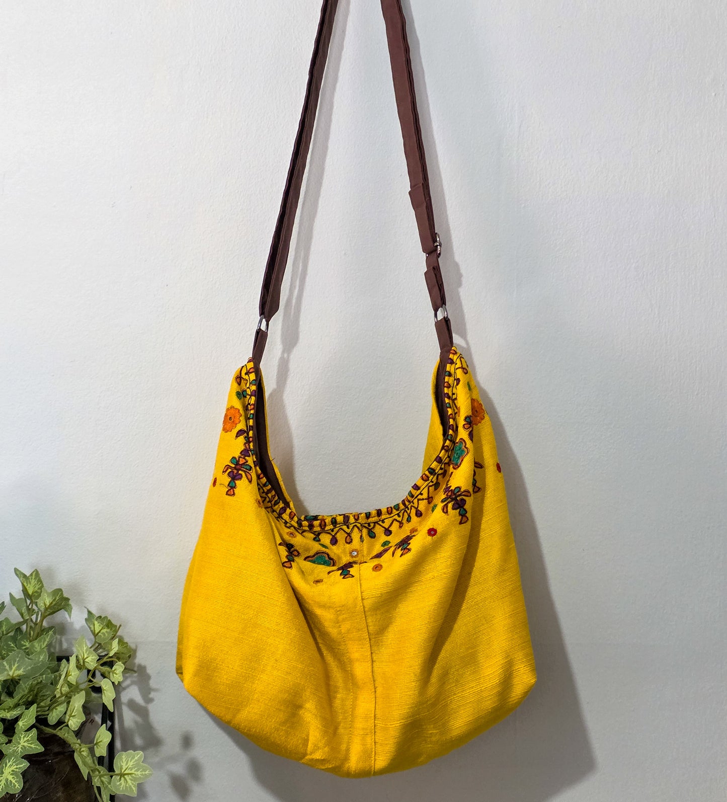 Yellow bag with floral embroidery on a white background