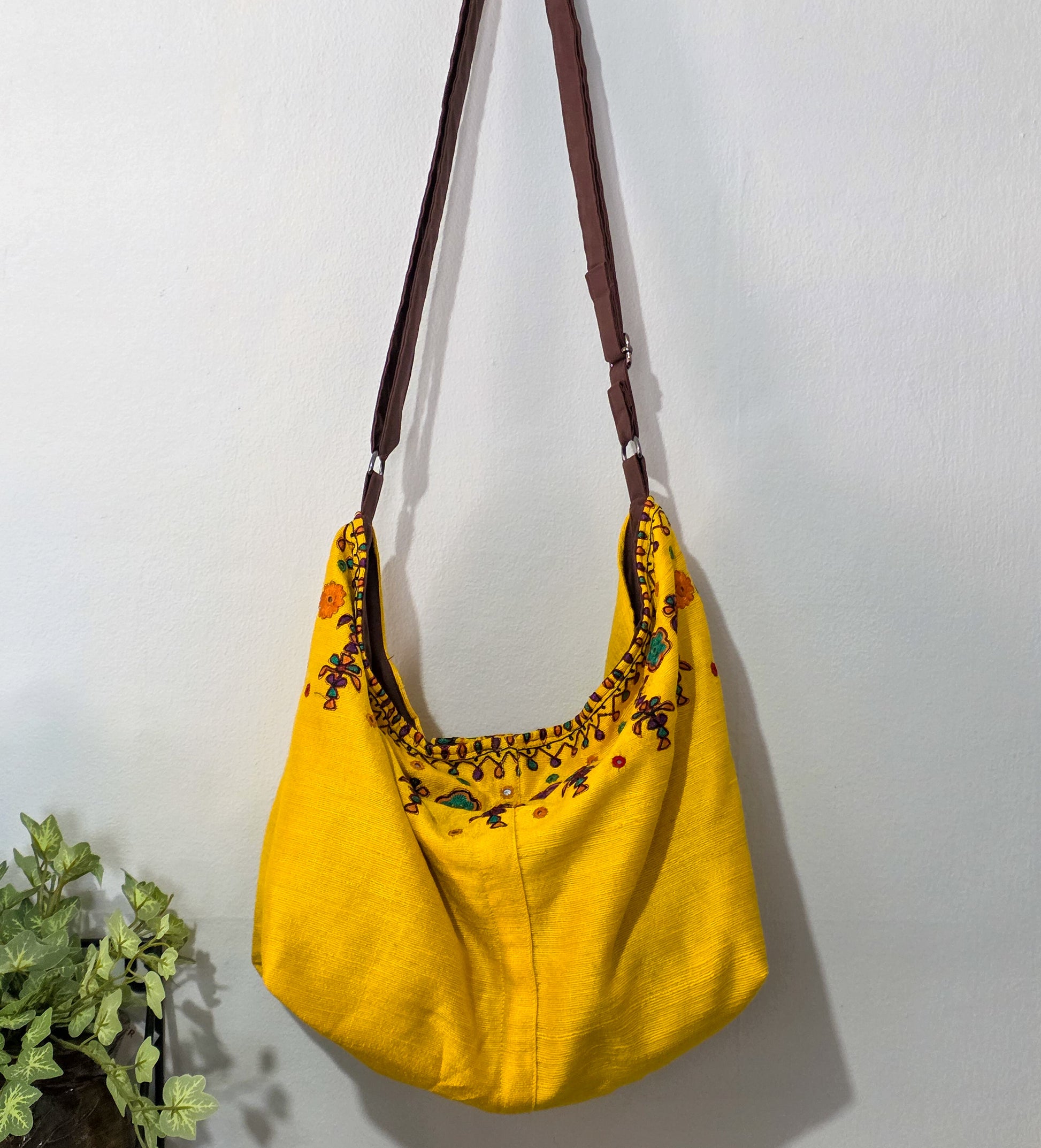Yellow bag with floral embroidery on a white background