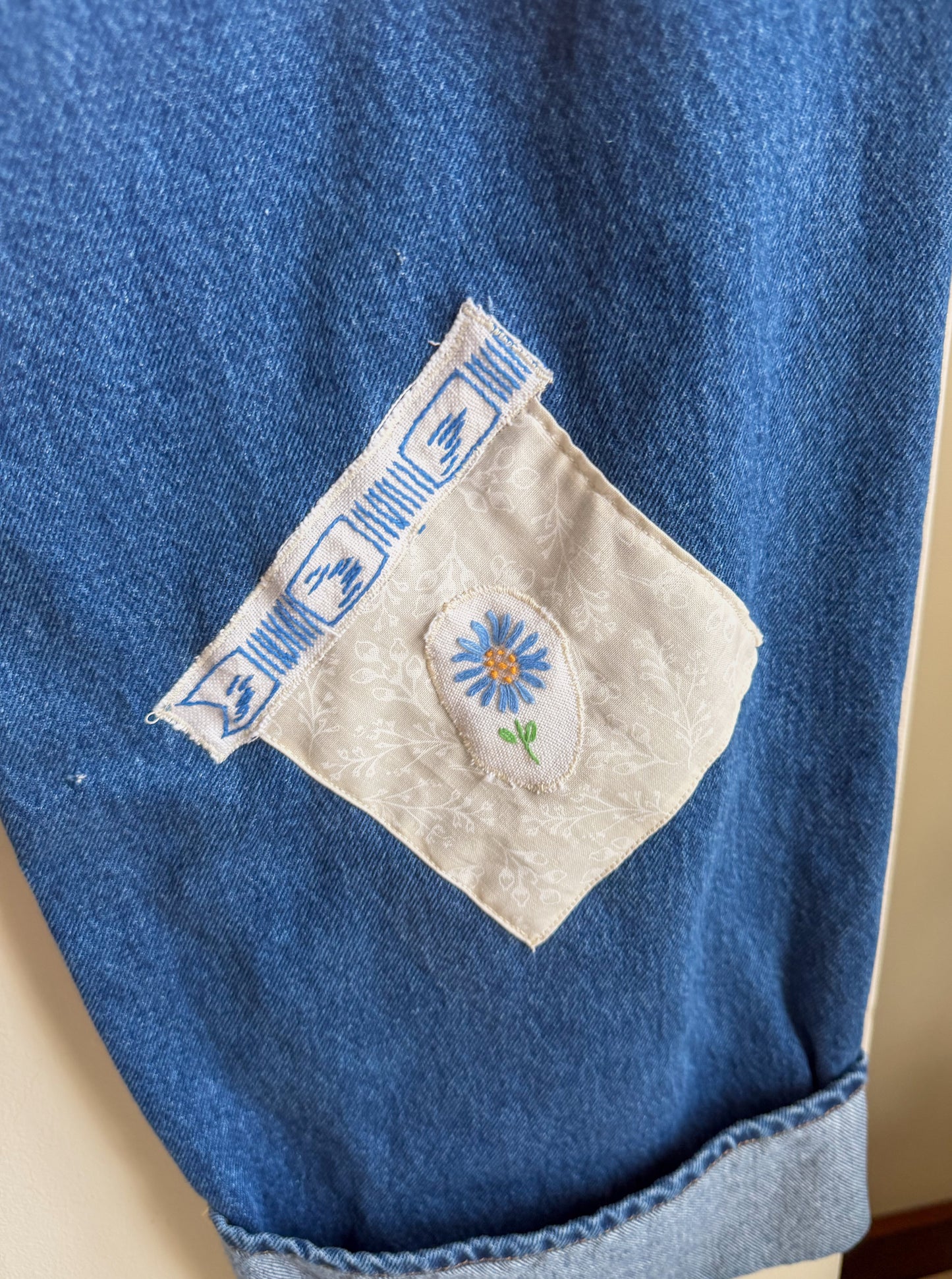 Close-up of a blue denim fabric with a embroidered flower design 