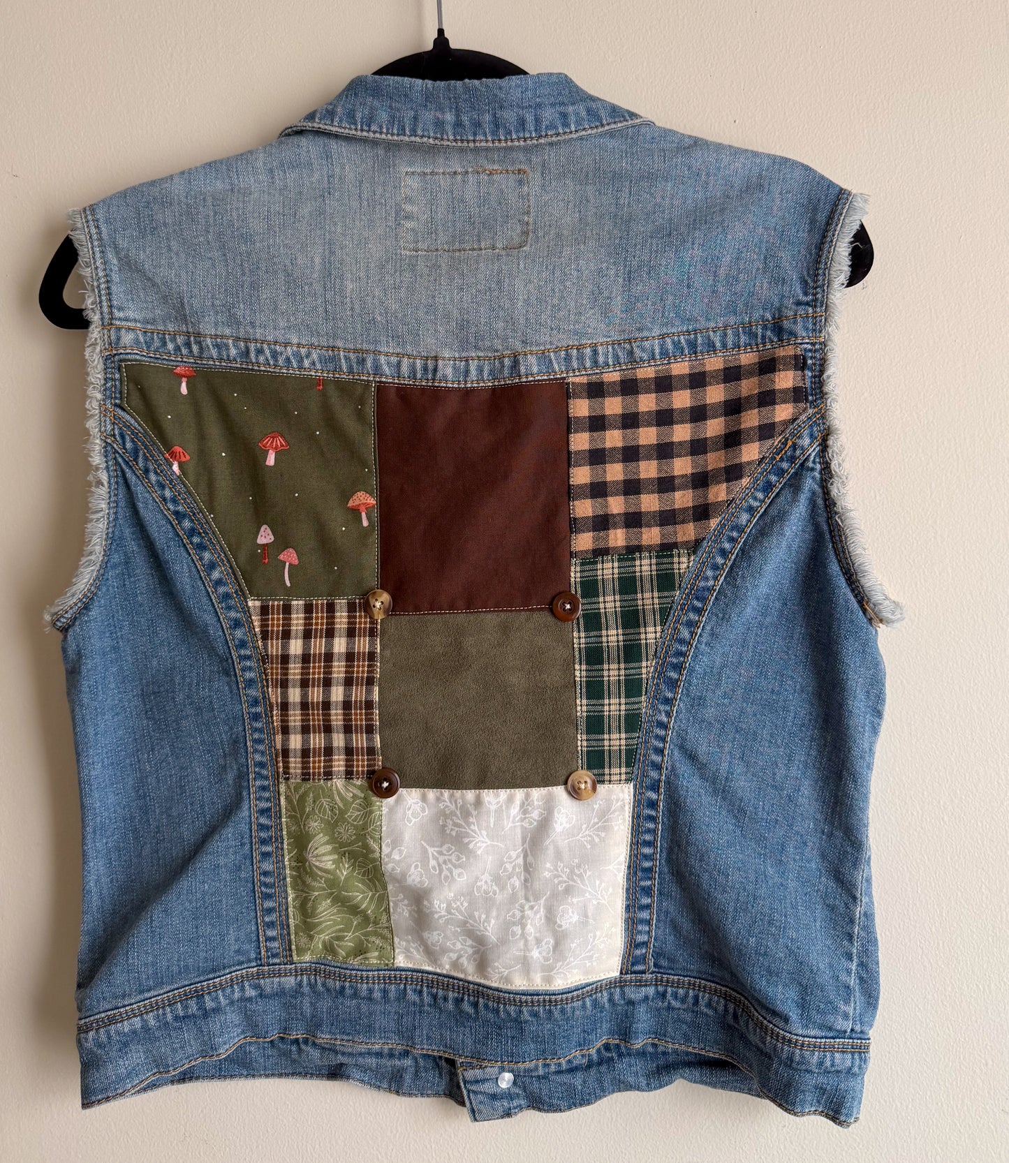 Denim vest with patchwork design on a beige background