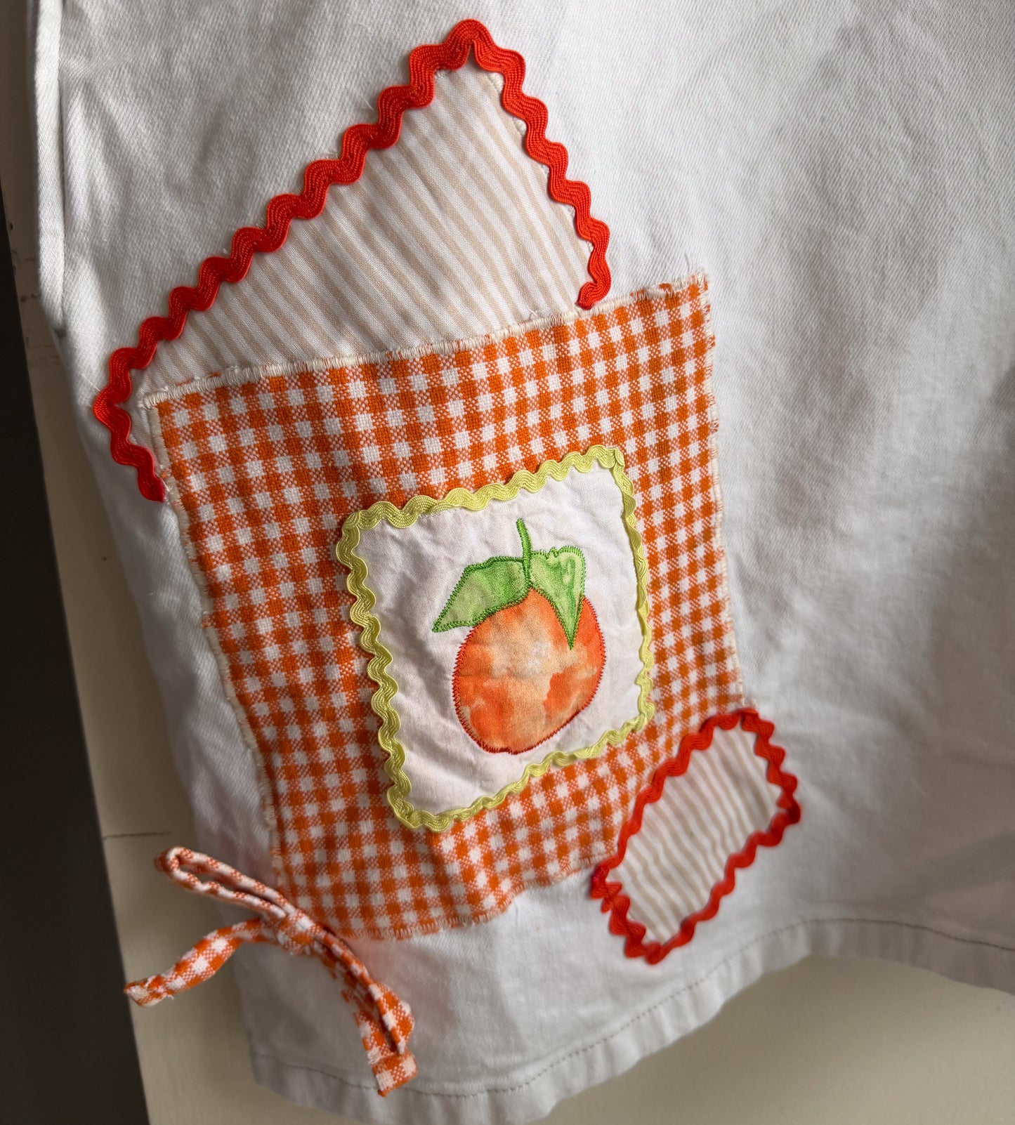 White dress with a peach illustration and orange checkered patch