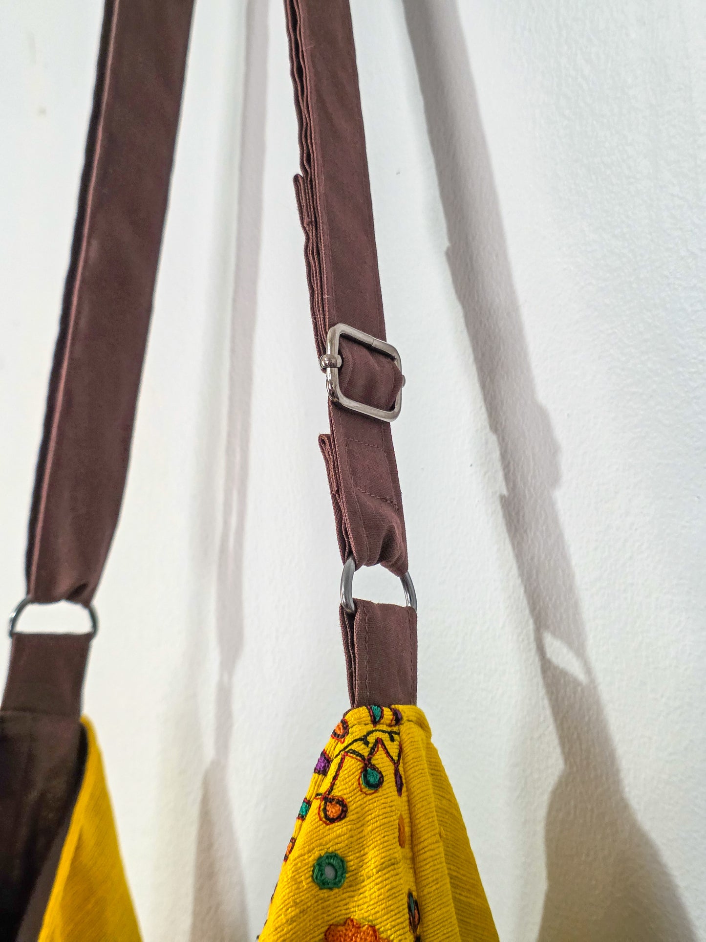 Yellow bag with brown strap on a white background