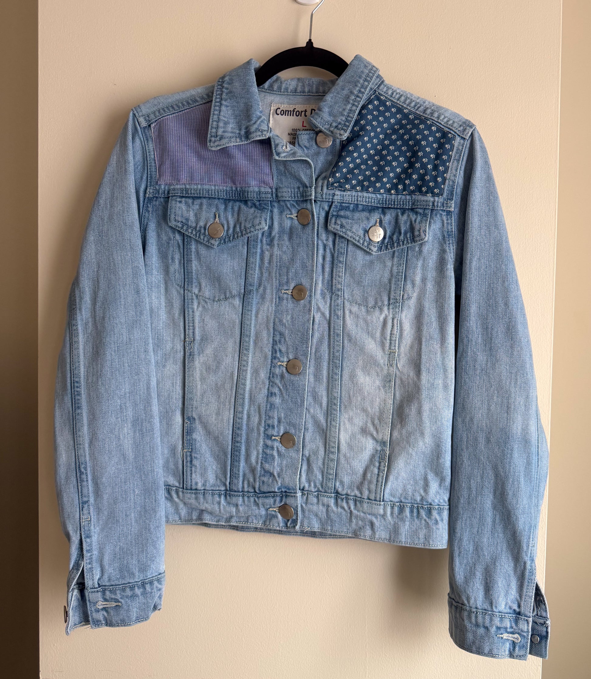 Blue denim jacket with a patterned collar on a beige background