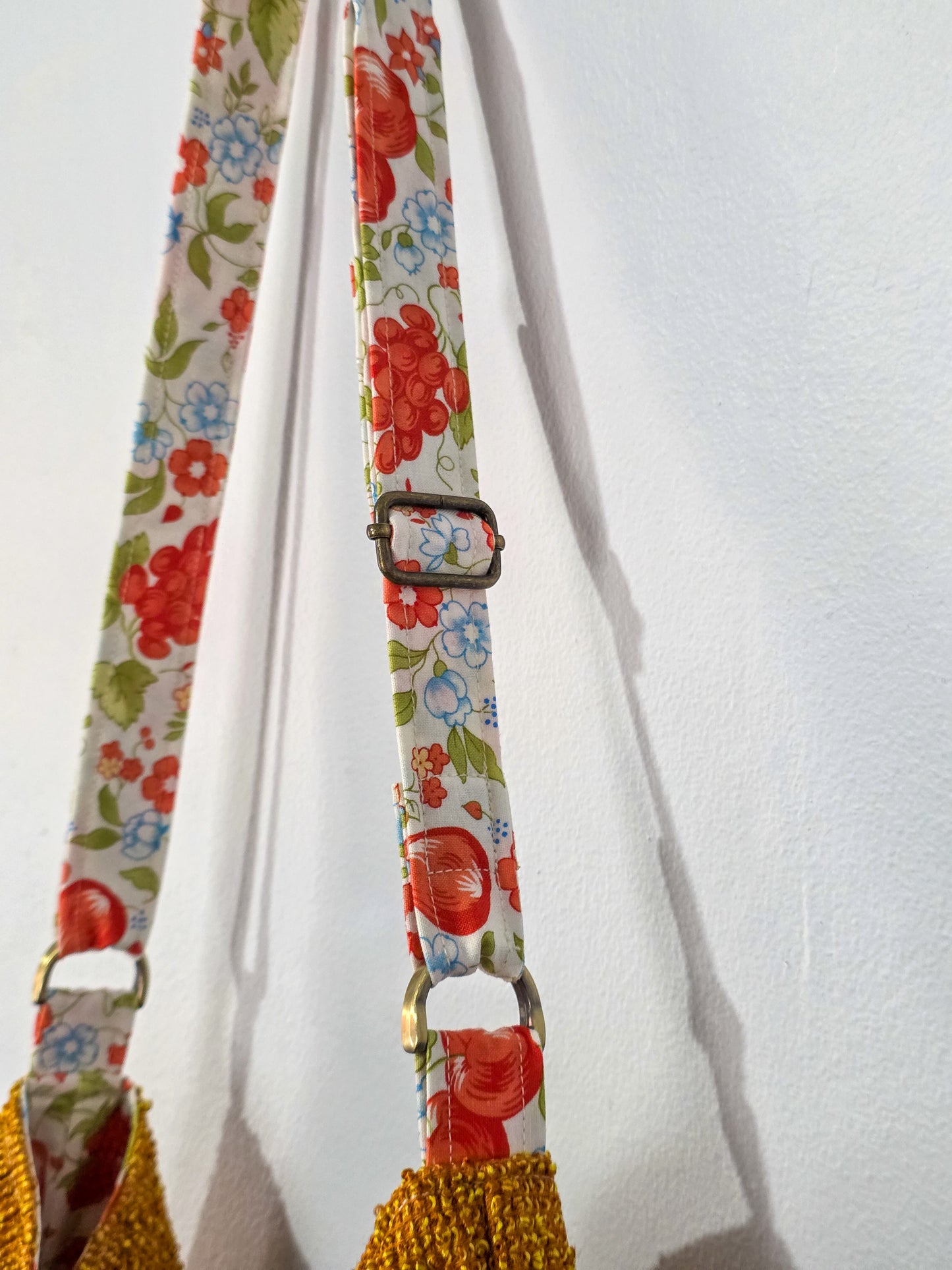 Floral patterned strap with a buckle on a white background