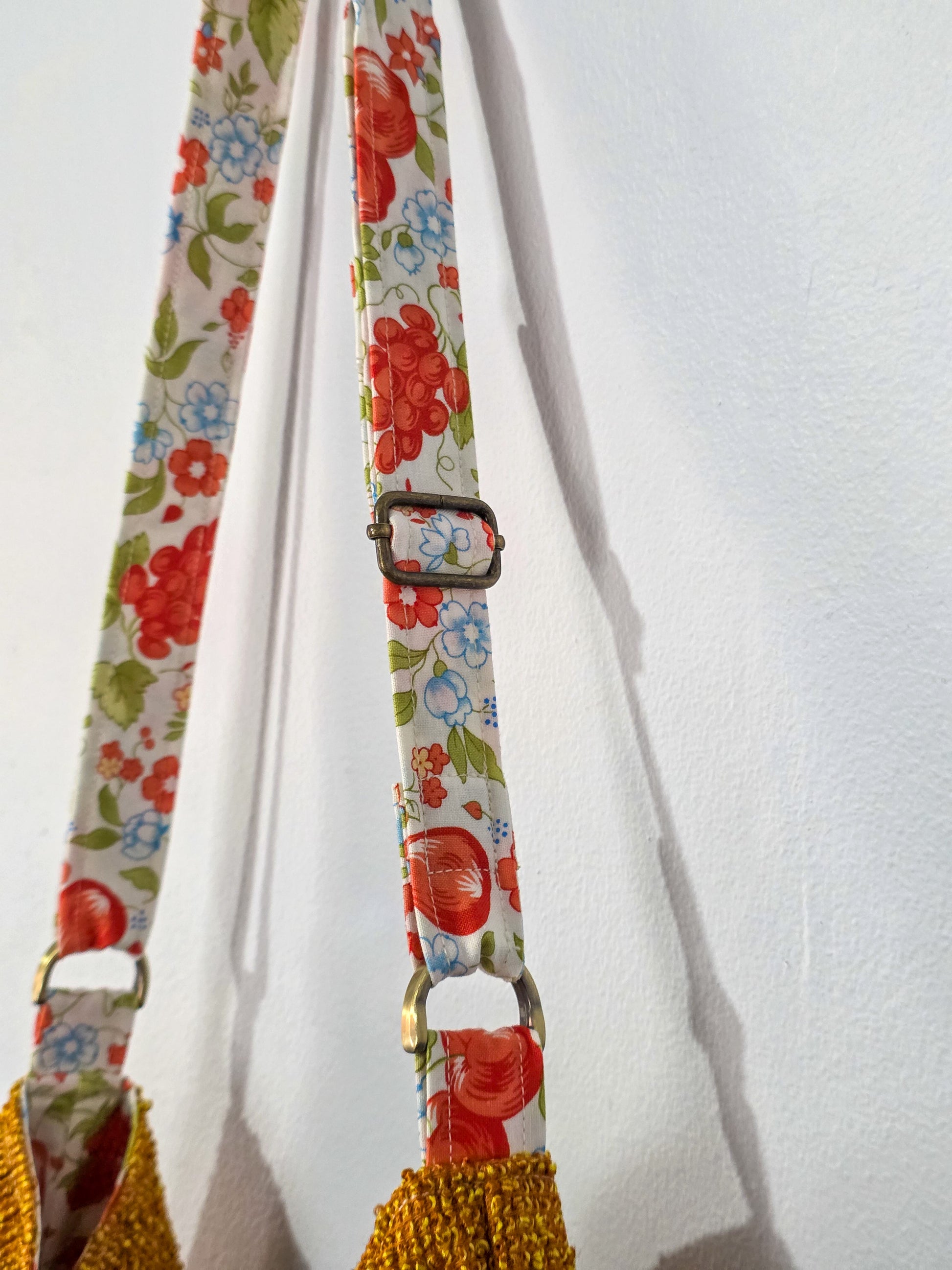 Floral patterned strap with a buckle on a white background