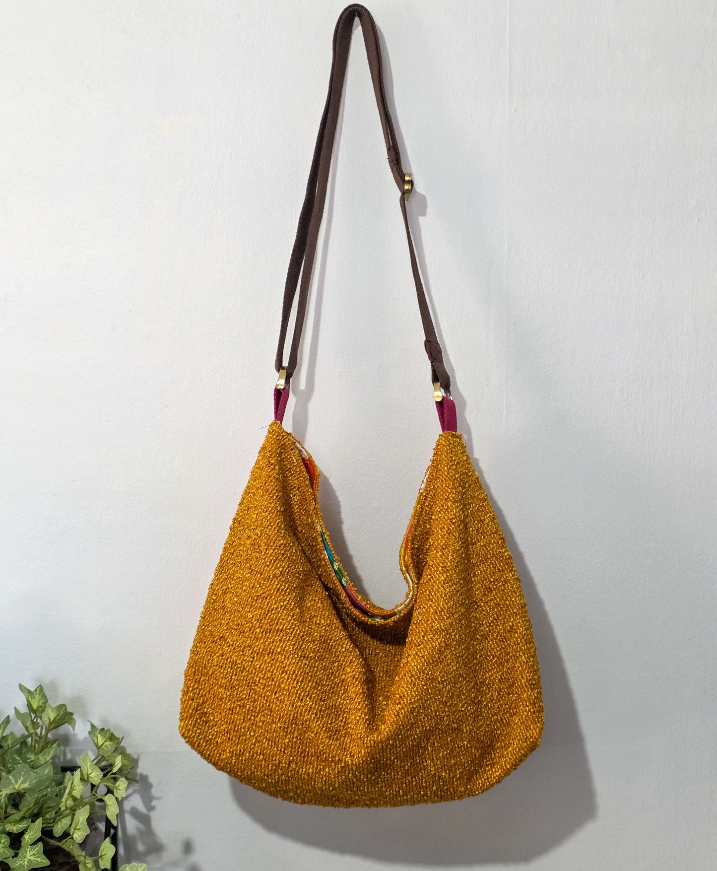 Yellow handbag with a brown strap on a white background