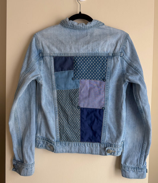 Denim jacket with patchwork design on a beige background